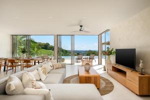 a living room with a couch and a tv at Stunning Koh Samui Villa with Infinity Pool & Ocean View "Villa Sabaï Dii" in Koh Samui