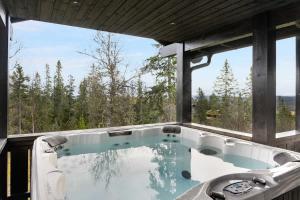 a jacuzzi tub with a view of the woods at Trysilfjell hytteområde 922 by Vacation Trysil in Trysil