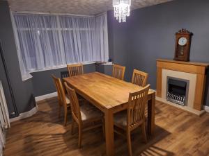 ein Esszimmer mit Tisch und Stühlen und einer Uhr in der Unterkunft Pearl Beach House, Lincs in Mablethorpe + 12 Fotos