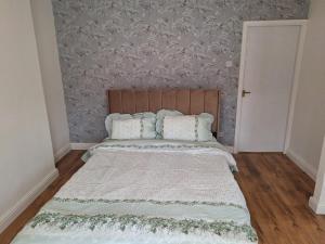 ein Schlafzimmer mit einem Bett mit einem hölzernen Kopfteil in der Unterkunft Pearl Beach House, Lincs in Mablethorpe