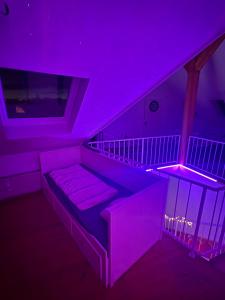 a living room with a couch in a purple room at Sky Harmony Penthouse mit Wasserbett, Jacuzzi und Grill in Villingen-Schwenningen