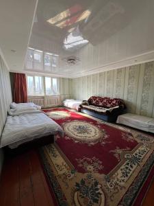 1 dormitorio con 2 camas y alfombra roja en Adventure Guest House, en Pokrovka