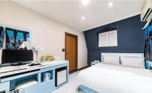 a bedroom with a blue accent wall and a bed at Dreaming Hostel Sinchon Hongdae in Seoul