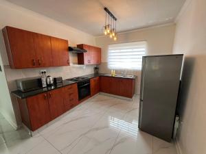 a kitchen with wooden cabinets and a stainless steel refrigerator at Waterfall Deluxe ll in Rustenburg