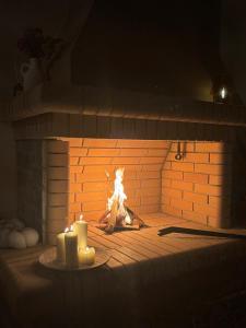 a fire in a brick oven with two candles at Ανέμη in Panayía