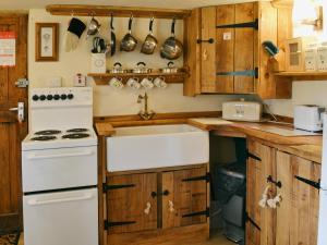 a kitchen with a white stove and a sink at Robins Nest - 29409 in Elmsted +8 photos