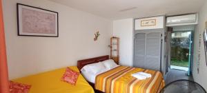 een kleine slaapkamer met twee bedden en een raam bij "Studio Bellevue" Terrasse et Deck vue mer-Accès piscine in Le Diamant