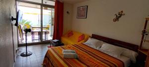 een slaapkamer met een bed en een raam bij "Studio Bellevue" Terrasse et Deck vue mer-Accès piscine in Le Diamant