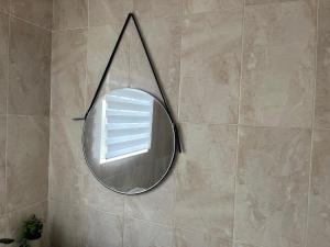 a mirror hanging on a wall in a bathroom at Waterfall Deluxe ll in Rustenburg