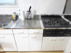 a kitchen with a stove and a sink at 豊橋南栄駅徒歩1分 最大9名一棟貸 ホタルヤ Guest House Hotaruya Toyohashi Minami Sakae in Toyohashi +24 photos