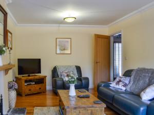 a living room with a couch and a tv at Ty Glyndwr in Ystalyfera