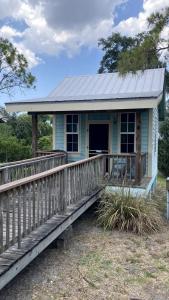 a small blue house with a wooden ramp leading to it at Lakefront Cabin Rental in Bradenton, Florida in Eastgate