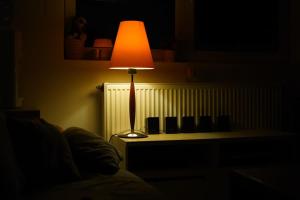 une lampe assise sur une table dans une pièce sombre dans l'établissement Bucharest Residence, à Bucarest