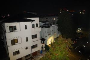 une vue aérienne d'un bâtiment blanc la nuit dans l'établissement Bucharest Residence, à Bucarest