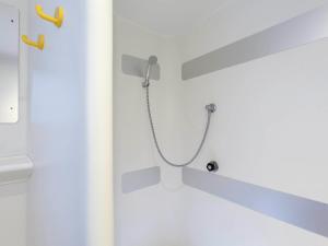 eine Dusche mit einem an der Wand befestigten Schlauch in der Unterkunft MELINESS Hotel in Saint-Marcel