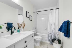 a white bathroom with a sink and a toilet at Bright and chic home with a cozy touch in Windsor +52 photos