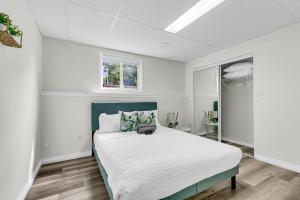 a white bedroom with a large bed in it at Bright and chic home with a cozy touch in Windsor