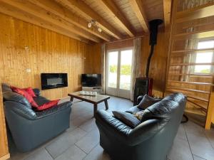 a living room with two leather chairs and a table at Au petit Suquet in Andregeat
