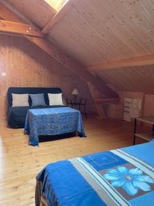 a room with two beds and a couch in a attic at Au petit Suquet in Andregeat