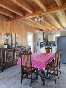a dining room with a pink table and chairs at Au petit Suquet in Andregeat