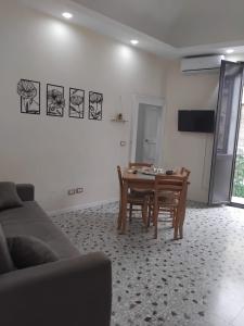 ein Wohnzimmer mit Tisch und Couch in der Unterkunft Il palazzo Dei Normanni in Motta SantʼAnastasia