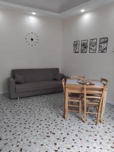 ein Wohnzimmer mit Sofa und Tisch in der Unterkunft Il palazzo Dei Normanni in Motta SantʼAnastasia