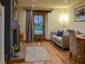 a living room with a couch and a table at Pippa's Cottage - Uk42332 in Little Blencow