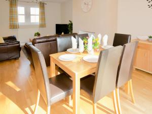 ein Esszimmer mit einem Holztisch und Stühlen in der Unterkunft Arden Cottage in Twynholm