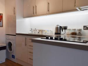 una cucina con fornello forno superiore accanto a una lavatrice di Royal Views a Keswick