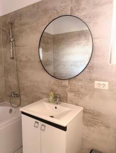 Un baño con un lavabo y un espejo en la pared. en Rodin Residence-New Apartment with Self Check In, en Colentina