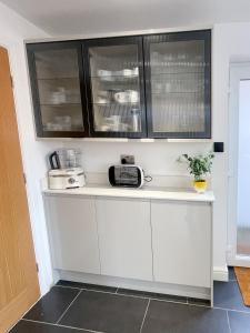 a kitchen with white counters and black cabinets at Walk to Addenbrookes - Stylish 1 bed Apartment in CBG +21 photos