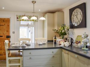 NewchurchにあるDevoniaのカウンターと壁に時計があるキッチン