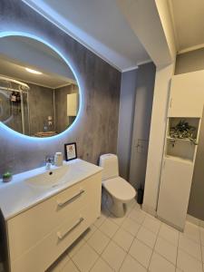 Un baño con lavabo, inodoro y espejo. en Cozy Tromsø apartment, No parking november to april, en Tromsø 10 fotos más