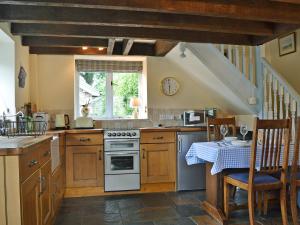 eine Küche mit Tisch und Herd oberen Backofen in der Unterkunft The Pigsty Cottage E2783 in Llanyblodwel