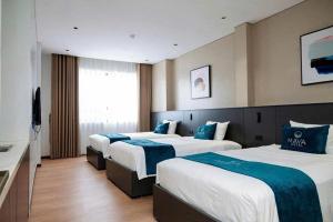 a hotel room with three beds and a television at Maya Hotel in Bản Giang +4 photos