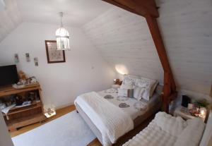 a small bedroom with a bed and a television at La parenthèse bucolique in Sepmes
