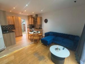 a living room with a blue couch and a kitchen at Connell Court in London