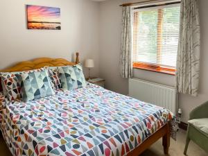 a bed with a colorful comforter in a bedroom at Swan in Welney