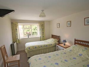ein Schlafzimmer mit zwei Betten und einem Fenster in der Unterkunft Maxmills Cottage - E1852 in Banwell