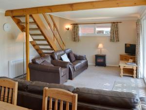 a living room with a couch and a staircase at Watersedge - E1106 in Horning