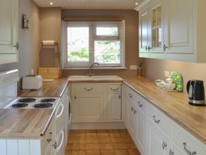a kitchen with white cabinets and a sink at Watersedge - E1106 in Horning +11 photos