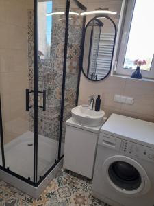 a bathroom with a shower and a washing machine at Mieszkanie w centrum Gogolina in Gogolin +16 photos