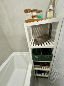 un baño con un estante blanco con cajones verdes en FH Apartment Letňany, en Praga