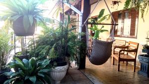 a room with a bunch of potted plants and swings at Pousada Colonial in Macaé