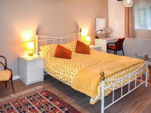una camera da letto con un grande letto con una coperta gialla di Fawns Cottage a Culmstock