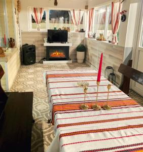 een woonkamer met een tafel met een kaars en een open haard bij Guest House Freya in Beli Iskar