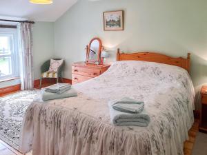 une chambre avec un lit avec des serviettes dessus dans l'établissement Greenrigg Cottage, à Caldbeck