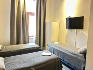 een hotelkamer met twee bedden en een flatscreen-tv bij CityGate Kraków in Krakau