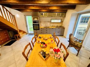 a kitchen with a wooden table with flowers on it at L'échappée belle - Maison - Proche Le Creusot in Marmagne +31 photos