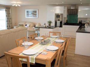 a kitchen and dining room with a wooden table and chairs at Apartment 11 - Latitude 51 in Westward Ho